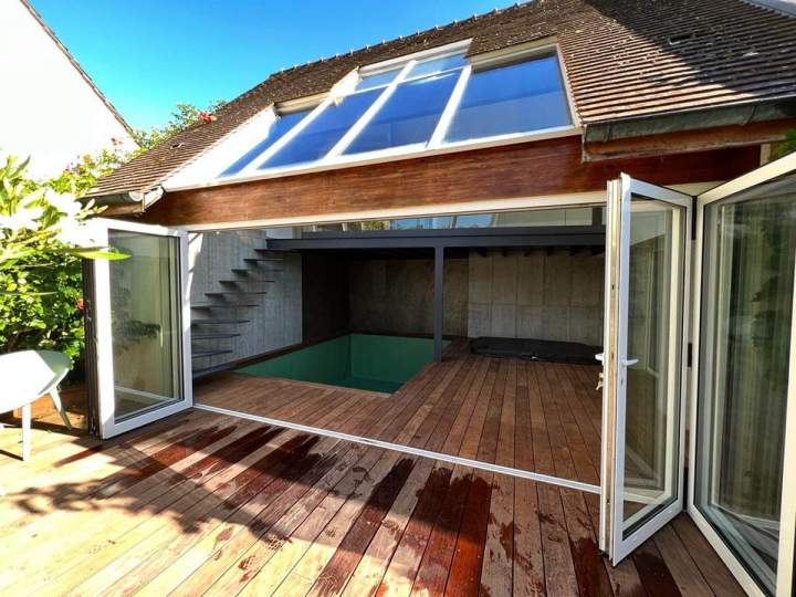 Terrasse en bois ouverte avec piscine intérieure et grandes baies vitrées, Montfermeil